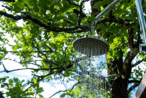 Photograph of the outdoor safari style shower in en-suite safari tent Samburu's bathroom. Shower under the oak trees with beautiful valley views. Glamping South West France.