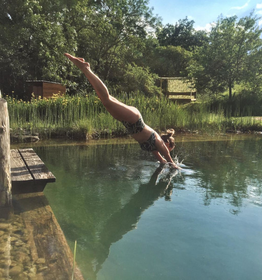 A happy guest diving into our natural swimming pool. The deep end is deep enough to jump, dive or cannon ball in. While the shallow end is ideal for toddlers.