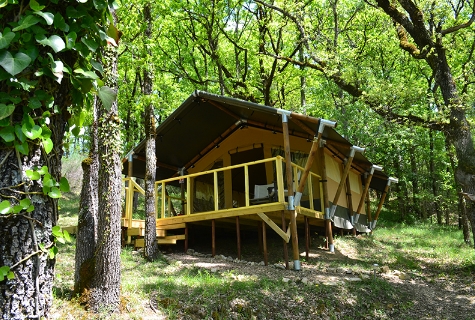 Exterior photograph of woodland safari tent Shimoni. A 16 square meter luxury tent surrounded by oak woodland. Located close to Le Camp's natural swimming pool.